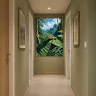 Green frog artwork with jungle scenery displayed in a hallway